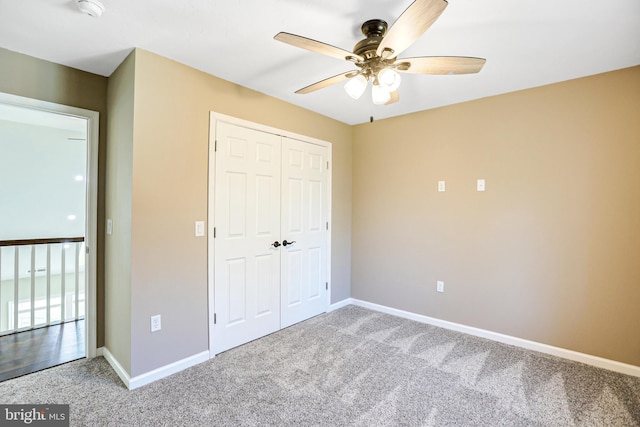 unfurnished bedroom with carpet flooring, ceiling fan, and a closet