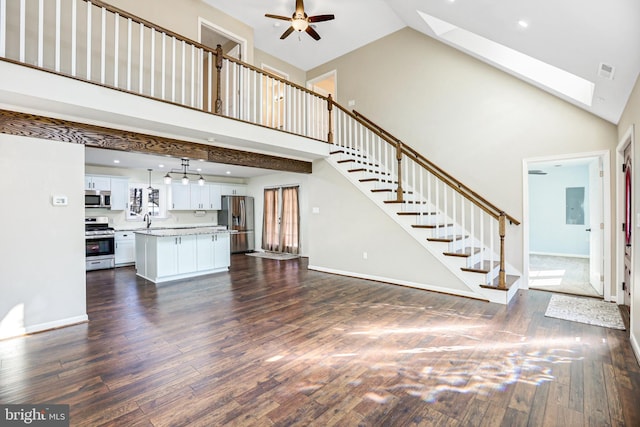 unfurnished living room featuring a skylight, ceiling fan, sink, high vaulted ceiling, and dark hardwood / wood-style floors