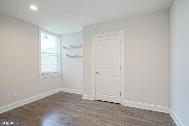 unfurnished room featuring dark wood-type flooring