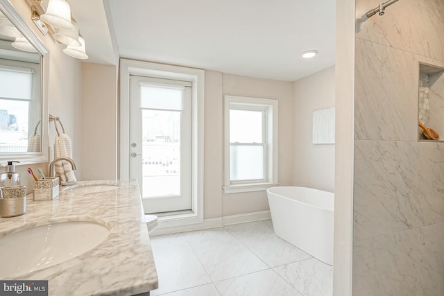 bathroom with vanity, a bath, and toilet