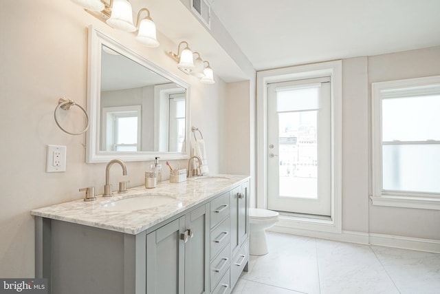 bathroom with vanity, toilet, and a wealth of natural light