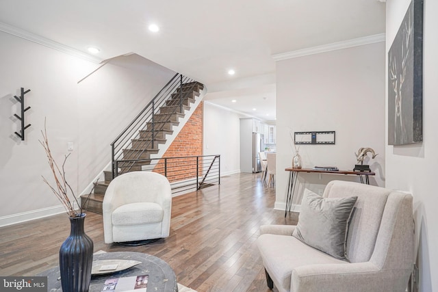 living area with hardwood / wood-style floors and crown molding