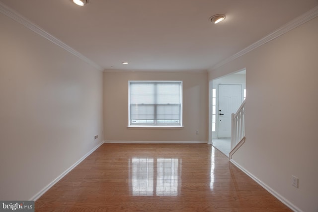 unfurnished room featuring light wood-type flooring and crown molding