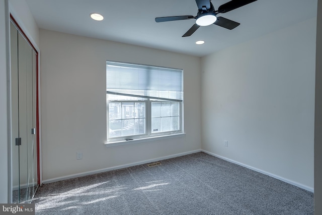 unfurnished bedroom with ceiling fan, a closet, carpet floors, and multiple windows