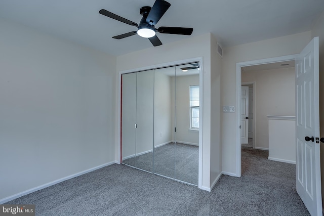 unfurnished bedroom with ceiling fan, a closet, and dark carpet