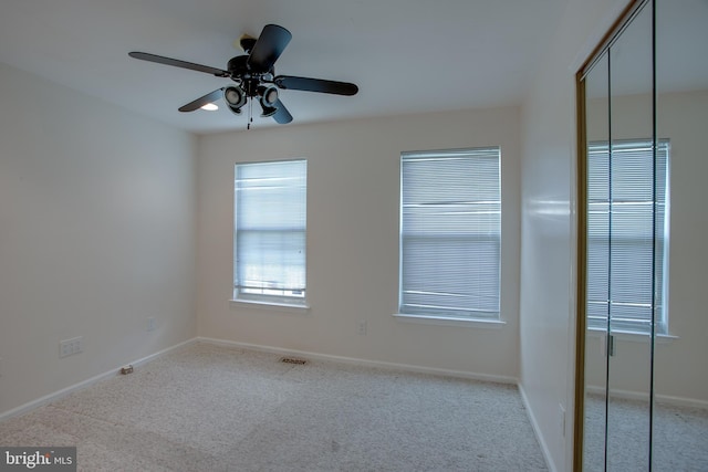 carpeted empty room featuring ceiling fan