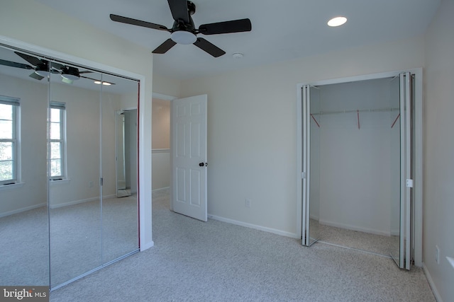 unfurnished bedroom with ceiling fan, light colored carpet, and a closet