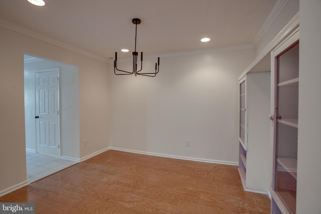 unfurnished dining area with an inviting chandelier, light hardwood / wood-style flooring, and crown molding