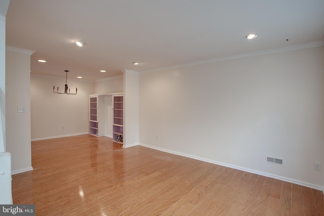 empty room with crown molding and light hardwood / wood-style flooring