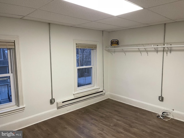 interior space featuring a baseboard heating unit and dark wood-type flooring