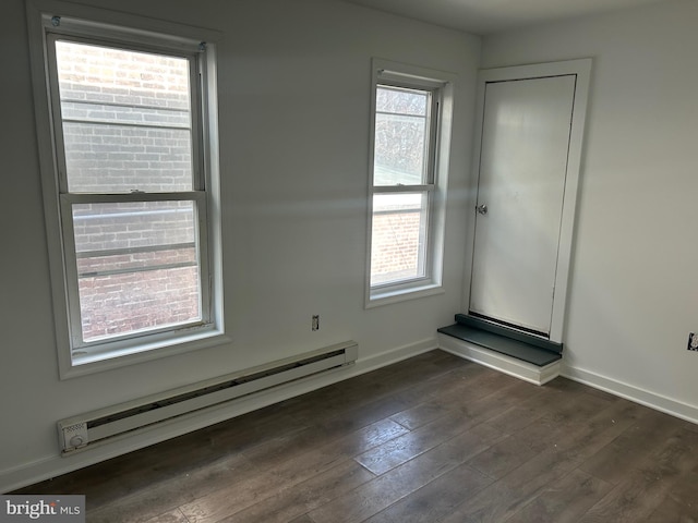 unfurnished room featuring a baseboard radiator and dark wood-type flooring