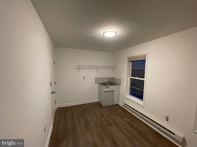 laundry room featuring a baseboard radiator and dark hardwood / wood-style floors