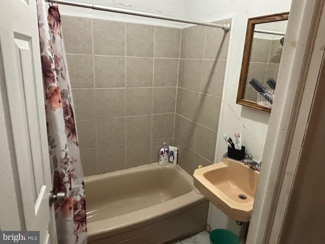 bathroom featuring shower / tub combo with curtain and sink