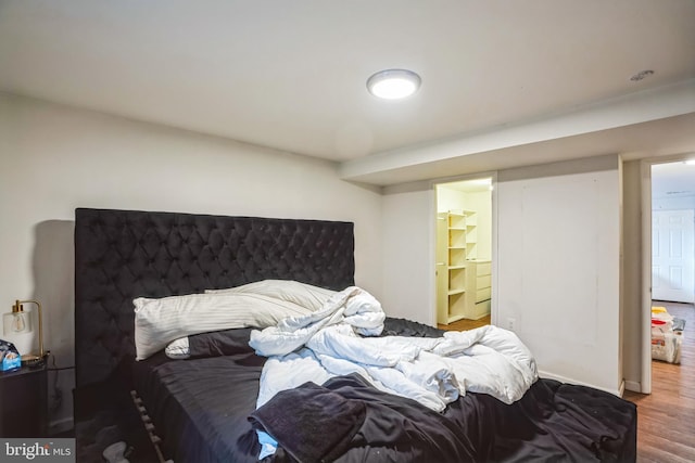 bedroom with wood finished floors and ensuite bathroom