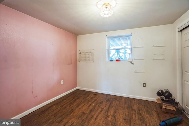 unfurnished room with dark wood-style flooring and baseboards