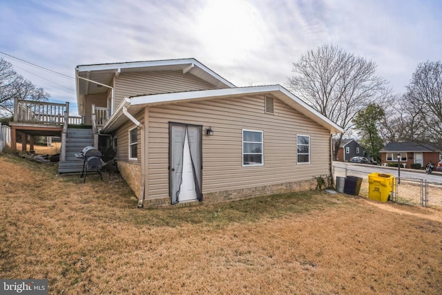 exterior space with a yard, stairway, a wooden deck, and fence