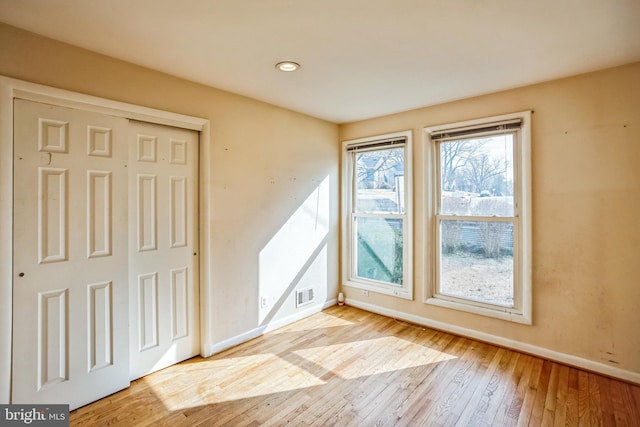 interior space featuring light wood finished floors, visible vents, and baseboards