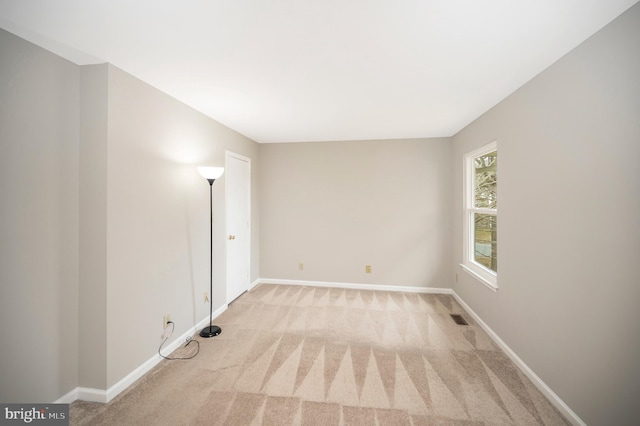 unfurnished room featuring light colored carpet