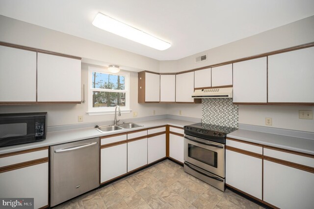 kitchen with decorative backsplash, sink, white cabinets, and appliances with stainless steel finishes