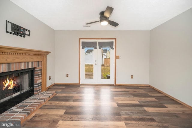 unfurnished living room with ceiling fan, a fireplace, and dark hardwood / wood-style floors