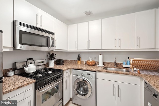 kitchen featuring stainless steel appliances, washer / clothes dryer, white cabinets, and light stone countertops