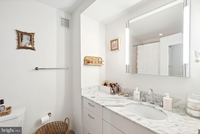 bathroom with toilet, curtained shower, and vanity