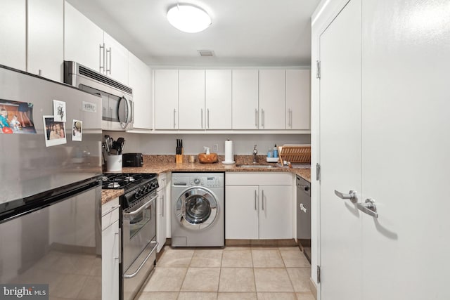 kitchen featuring stainless steel appliances, white cabinetry, washer / clothes dryer, and light stone countertops