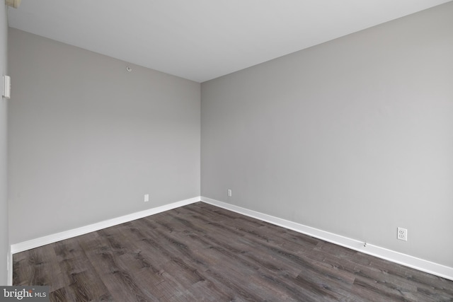 unfurnished room with dark wood-type flooring