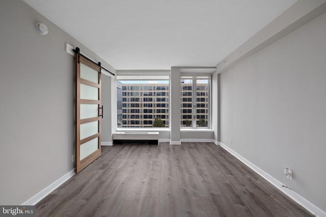 spare room with a barn door and hardwood / wood-style flooring