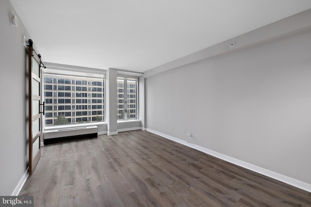 spare room with a barn door and hardwood / wood-style floors