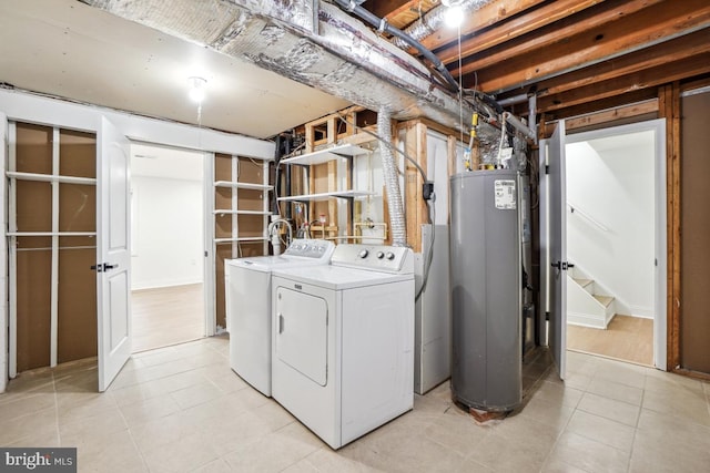 clothes washing area with washer and dryer and water heater