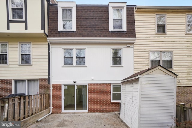 rear view of house with a storage unit