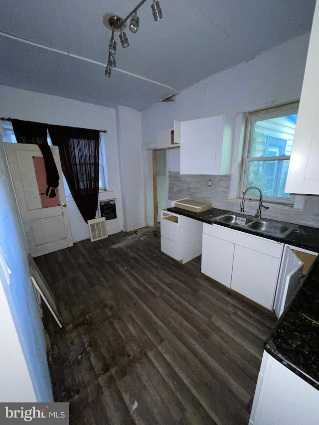 kitchen featuring white cabinets, decorative backsplash, and sink