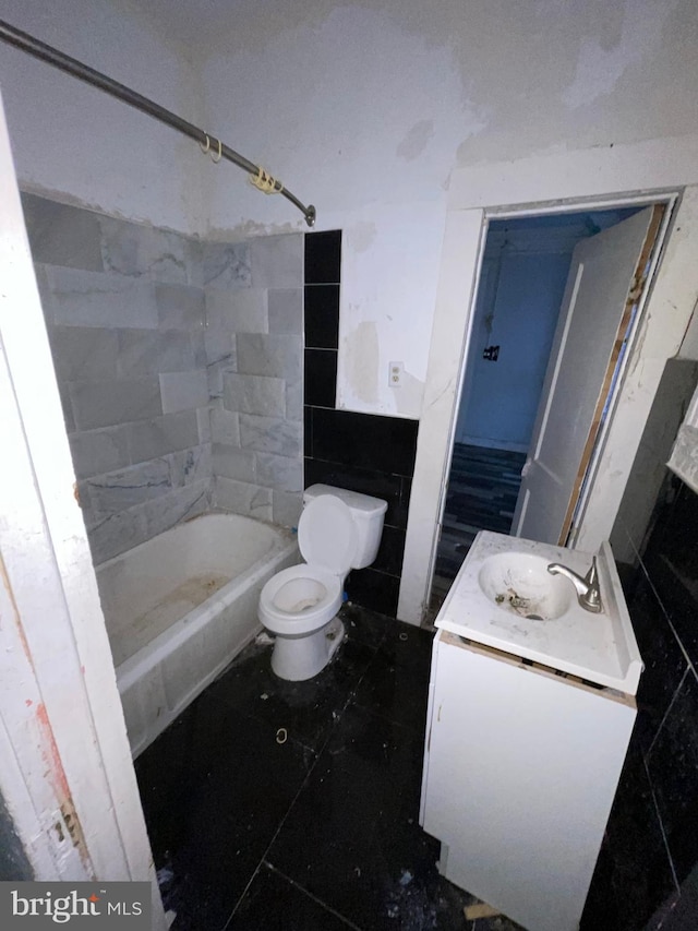 full bathroom featuring vanity, tiled shower / bath combo, and toilet