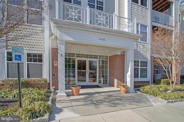 property entrance featuring a balcony and french doors