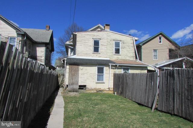 rear view of property with a lawn