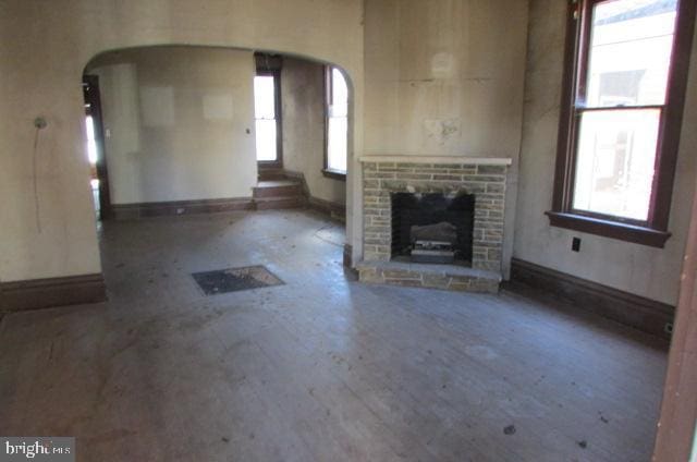 unfurnished living room featuring a fireplace and plenty of natural light