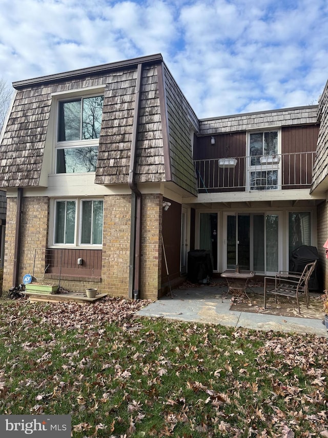 back of property with a balcony and a patio