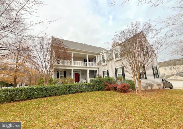 view of front of house featuring covered porch, a balcony, and a front yard