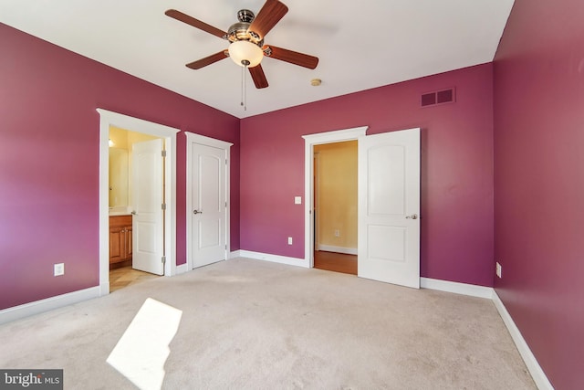 unfurnished bedroom featuring ceiling fan, light colored carpet, and connected bathroom