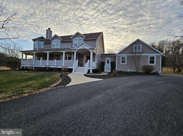 view of front facade with a lawn and covered porch