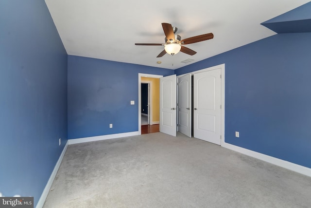 unfurnished bedroom featuring carpet, ceiling fan, vaulted ceiling, and a closet