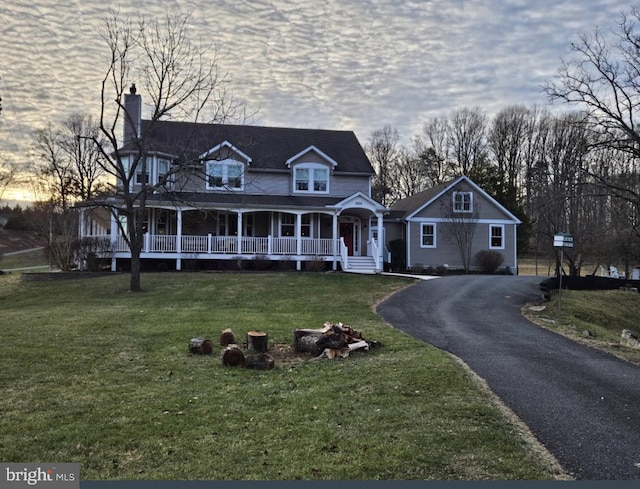 view of front of property featuring a porch and a lawn