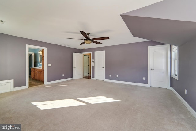 unfurnished bedroom featuring light carpet, ensuite bath, and ceiling fan