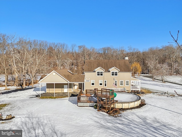 snow covered house with a wooden deck