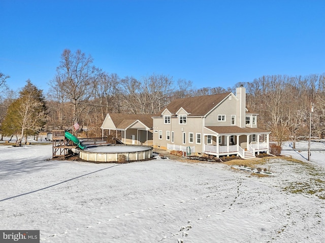 snow covered house featuring covered porch