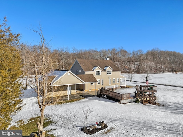 snow covered rear of property featuring a wooden deck