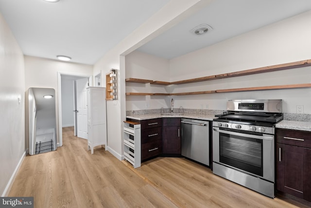 kitchen featuring dark brown cabinets, light wood-type flooring, stainless steel appliances, and sink