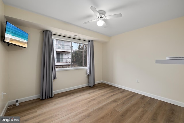 empty room with ceiling fan and light hardwood / wood-style flooring