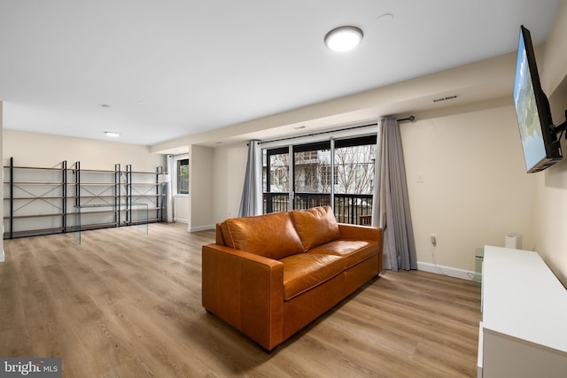 living room with light wood-type flooring and plenty of natural light